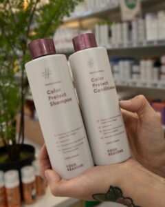 Nainen pitää käsissään Four Reasons Color Protect shampoota