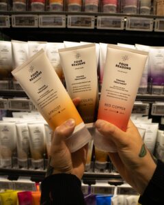 Nainen pitää käsissään Four Reasons Color Mask tuotteita